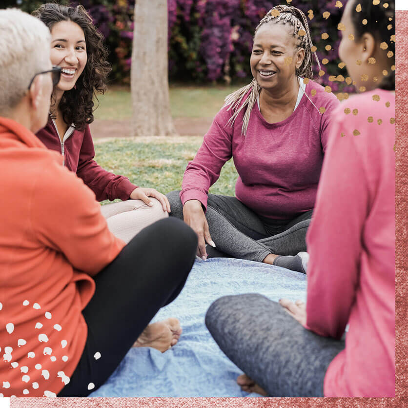 Happy multi generational women having fun together sitting outdoors at city park - Focus on african senior face